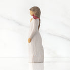 willow tree messenger figurine  of a woman with a white dress and red bird on a light gray background