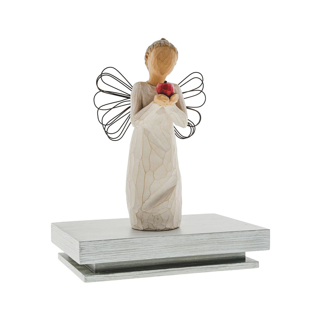willow tree Angel figurine holding a red heart on a white background